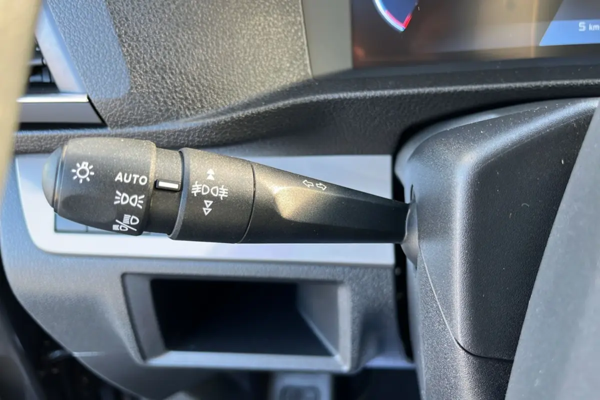 Gros plan sur la manette de commande des feux et clignotants dans l'habitacle du Peugeot Traveller gris titane.