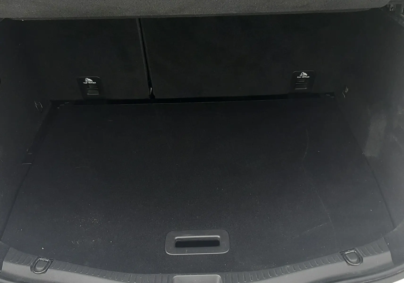 Coffre ouvert vu de l'arrière d'un Renault Scenic IV blanc nacré avec intérieur noir, espace de chargement vide.