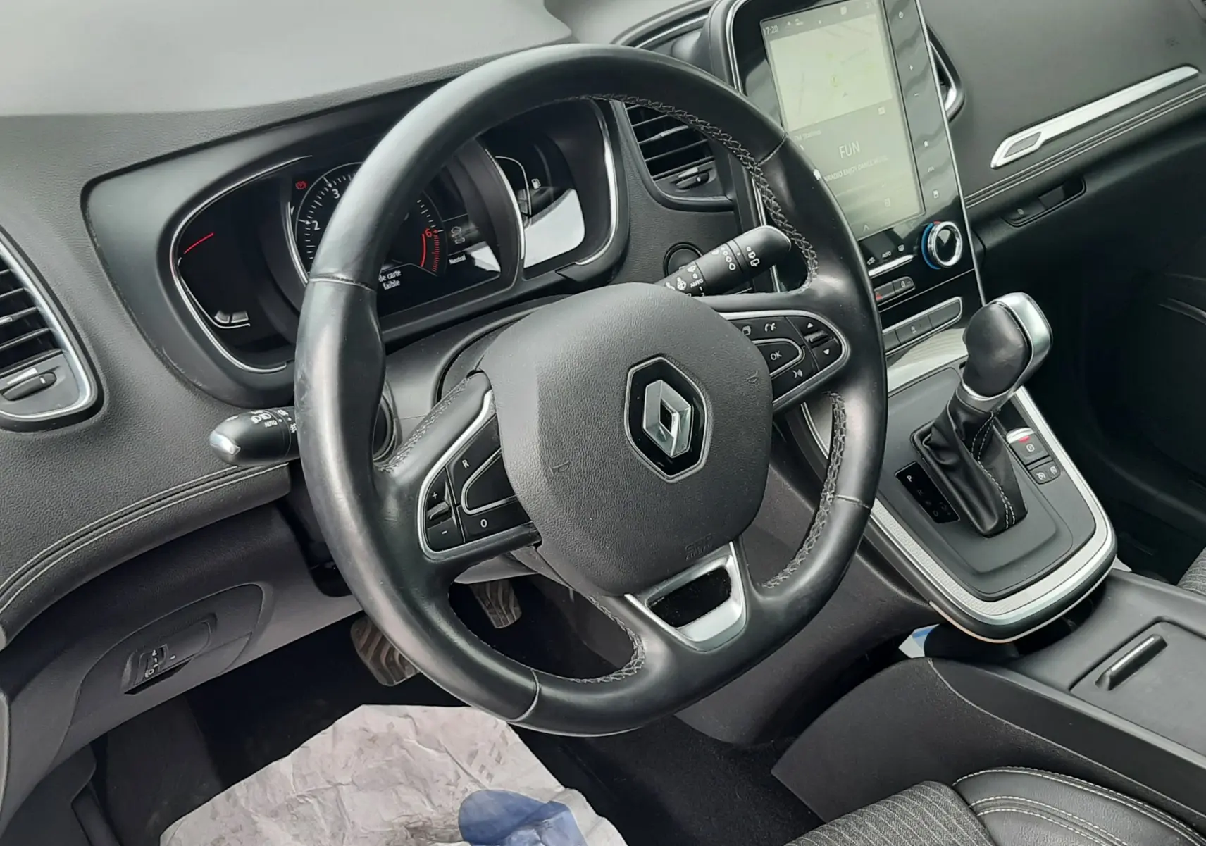 Vue intérieure du poste de conduite du Renault Scénic IV 1.3 TCE 140 Intens, volant cuir noir et console centrale avec écran tactile.