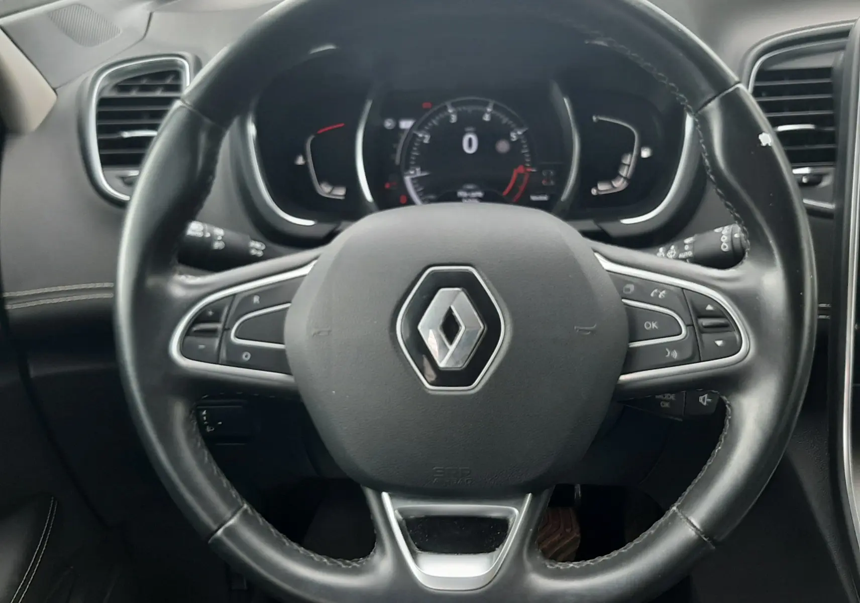Vue rapprochée du volant noir du Renault Scénic IV 1.3 TCE 140 Intens avec commandes intégrées et tableau de bord numérique.