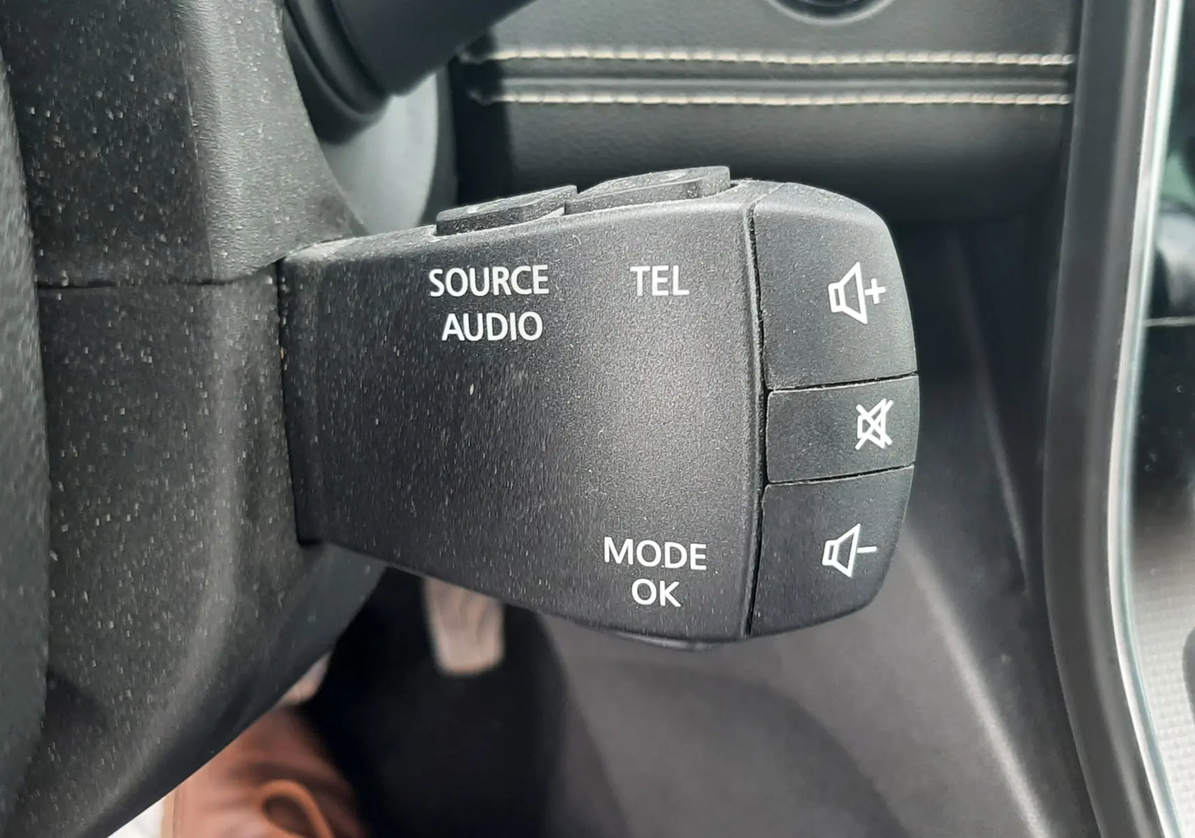 Gros plan sur la commande au volant noire du Renault Scénic IV 1.3 TCE 140 Intens, avec boutons audio et téléphone.