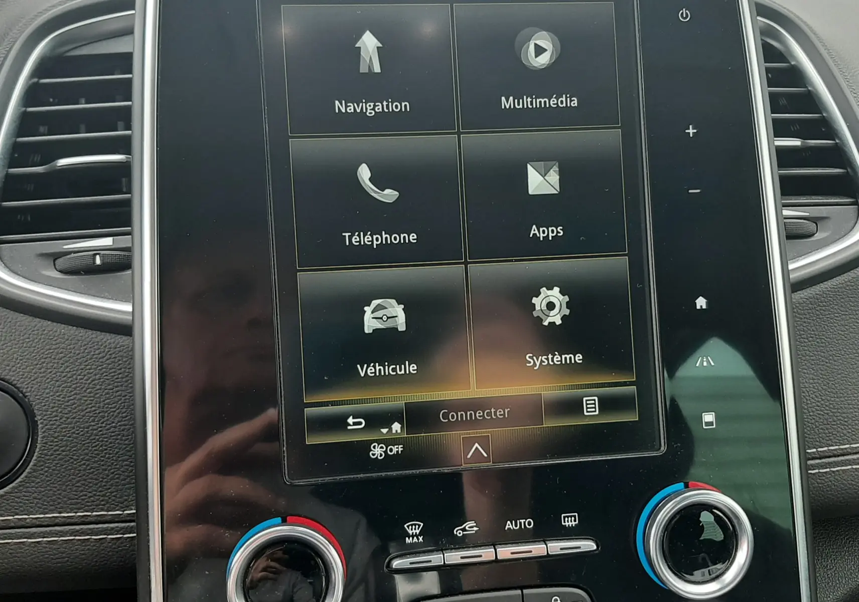 Écran tactile central du tableau de bord du Renault Scénic IV, affichant le menu principal avec commandes climatisation en bas.
