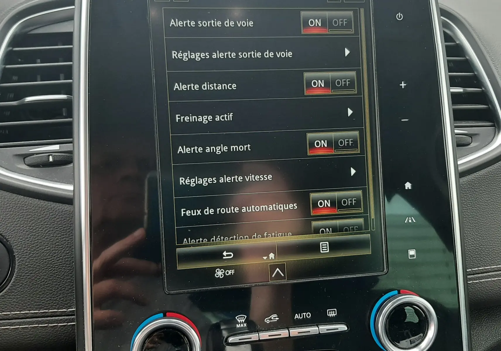 Écran tactile central du Renault Scénic IV blanc nacré, affichant les aides à la conduite avec options activées.