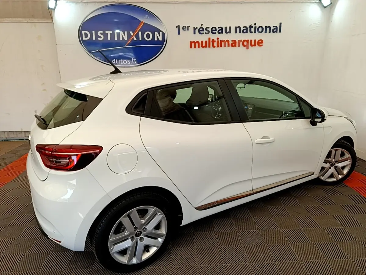 Vue côté droit d'une Renault Clio Business Blue dCi 85 blanche, avec jantes alliage et feux arrière LED visibles.