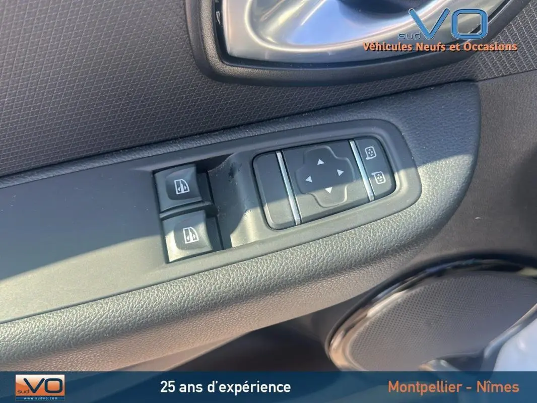 Gros plan sur les commandes électriques des vitres et des rétroviseurs côté conducteur d'une Renault Clio IV Estate Business blanche.