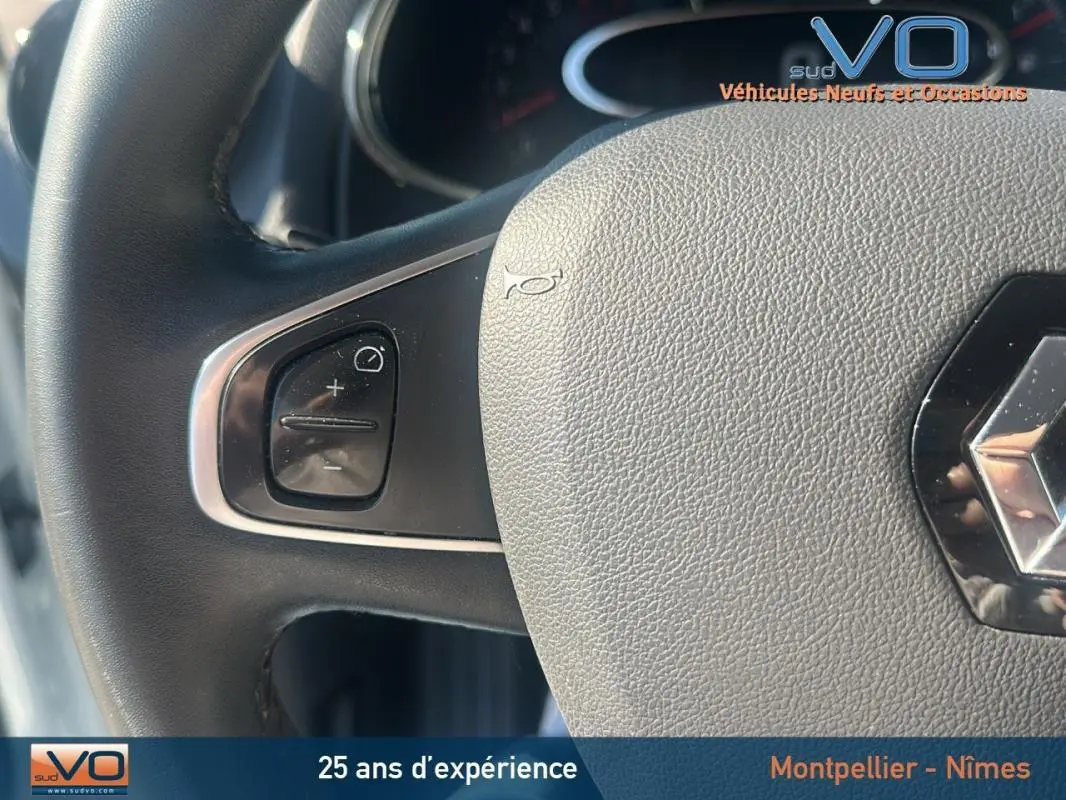 Gros plan sur le volant cuir de la Renault Clio IV Estate Business blanc, montrant les commandes au volant côté gauche.
