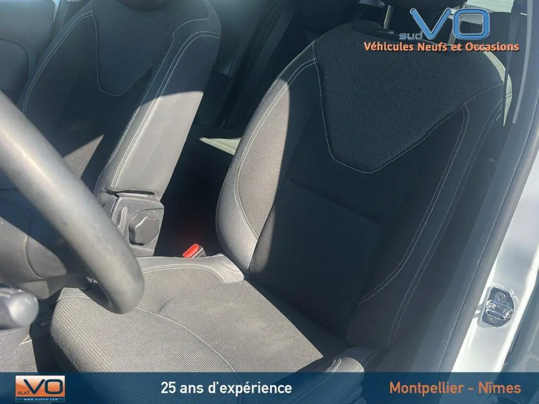 Siège conducteur en tissu noir de la Renault Clio IV Estate Business blanc, vue intérieure côté gauche avec volant partiel visible.