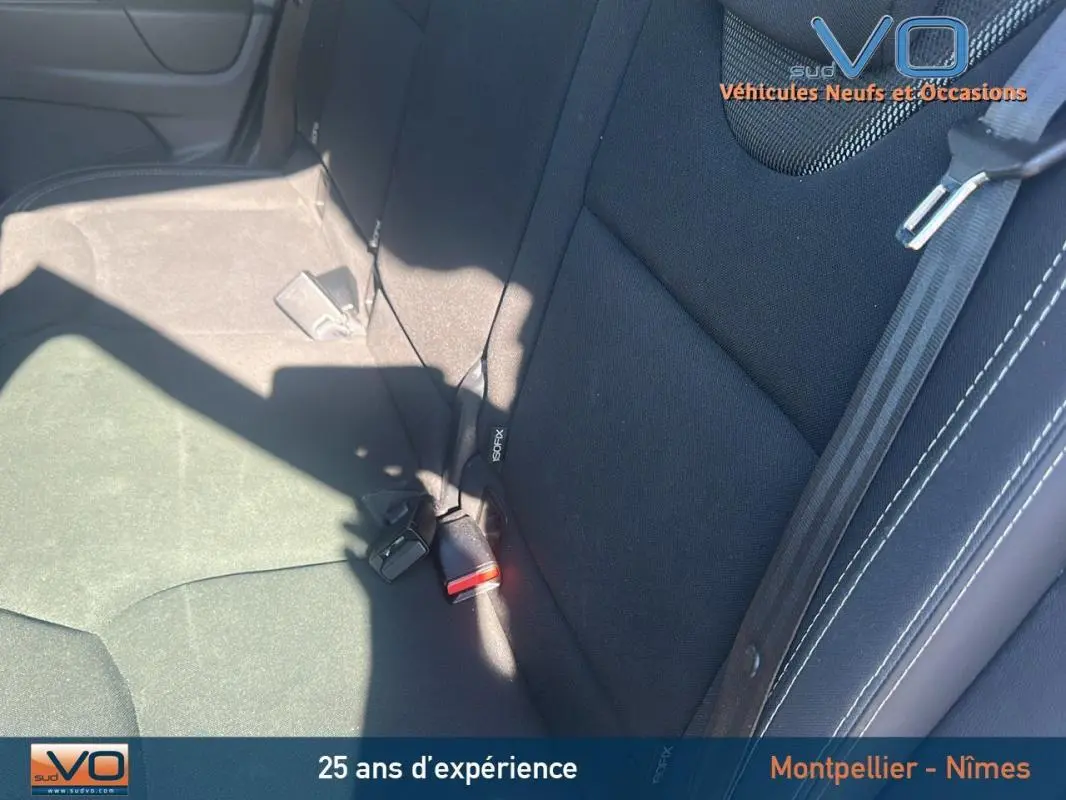 Vue rapprochée des sièges arrière noirs de la Renault Clio IV Estate Business blanche, montrant les ceintures et appuis-tête.