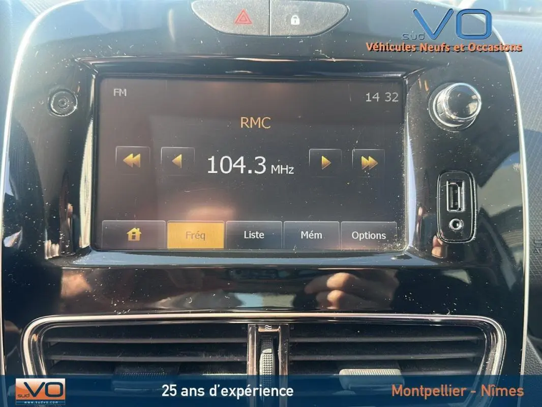 Vue rapprochée de l'écran multimédia noir de la Renault Clio IV Estate Business blanc affichant la radio FM sur 104.3 MHz