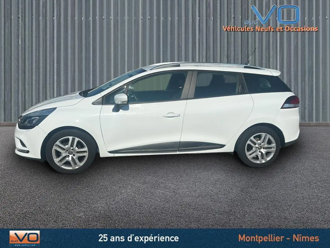 Profil droit d'une Renault Clio IV Estate Business blanche de 2019 avec vitres surteintées et jantes alliage visibles.