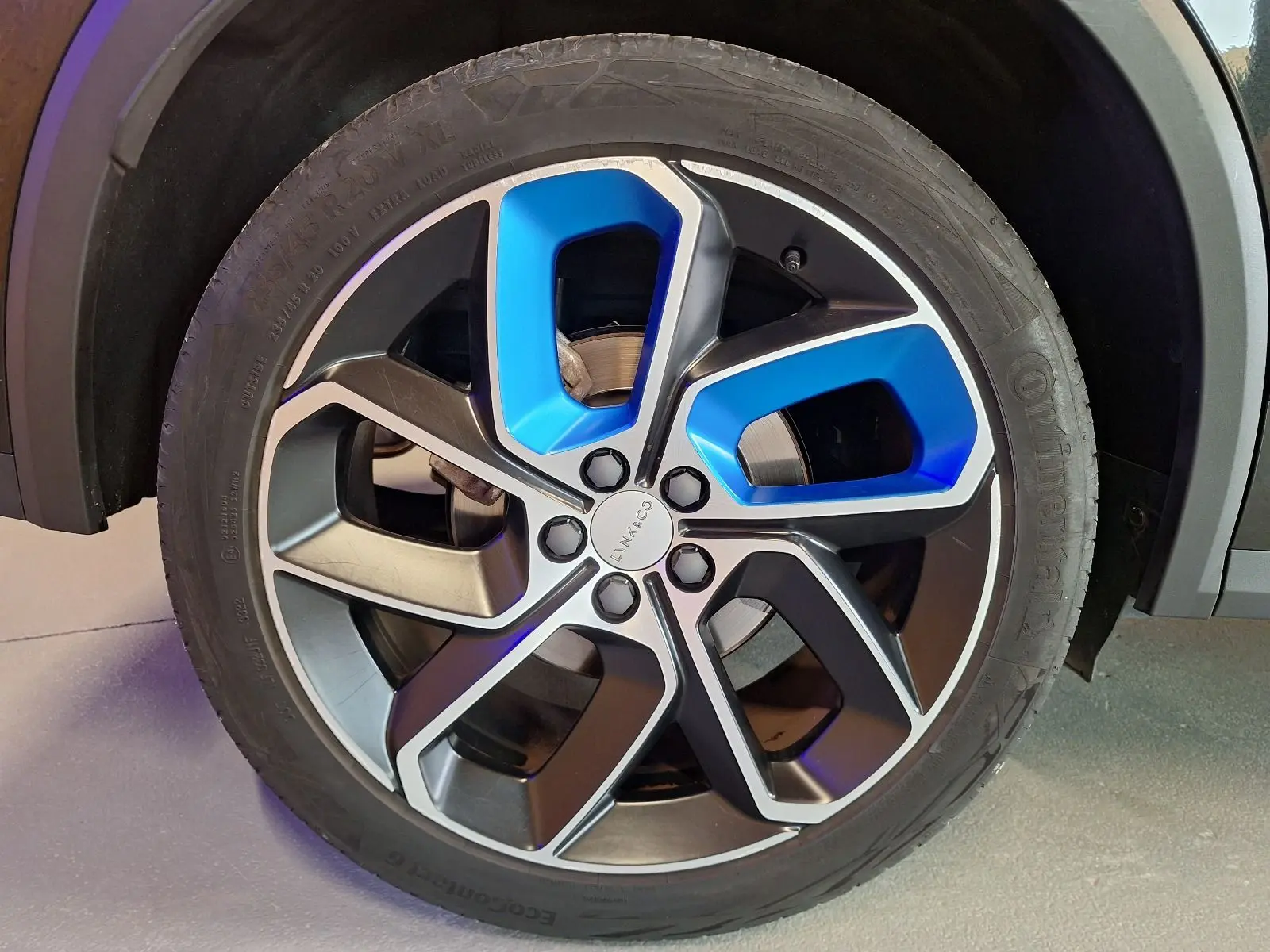 Gros plan sur la jante alliage 20 pouces bicolore noir et bleu du LYNK & CO 01 PHEV 2022 noir.