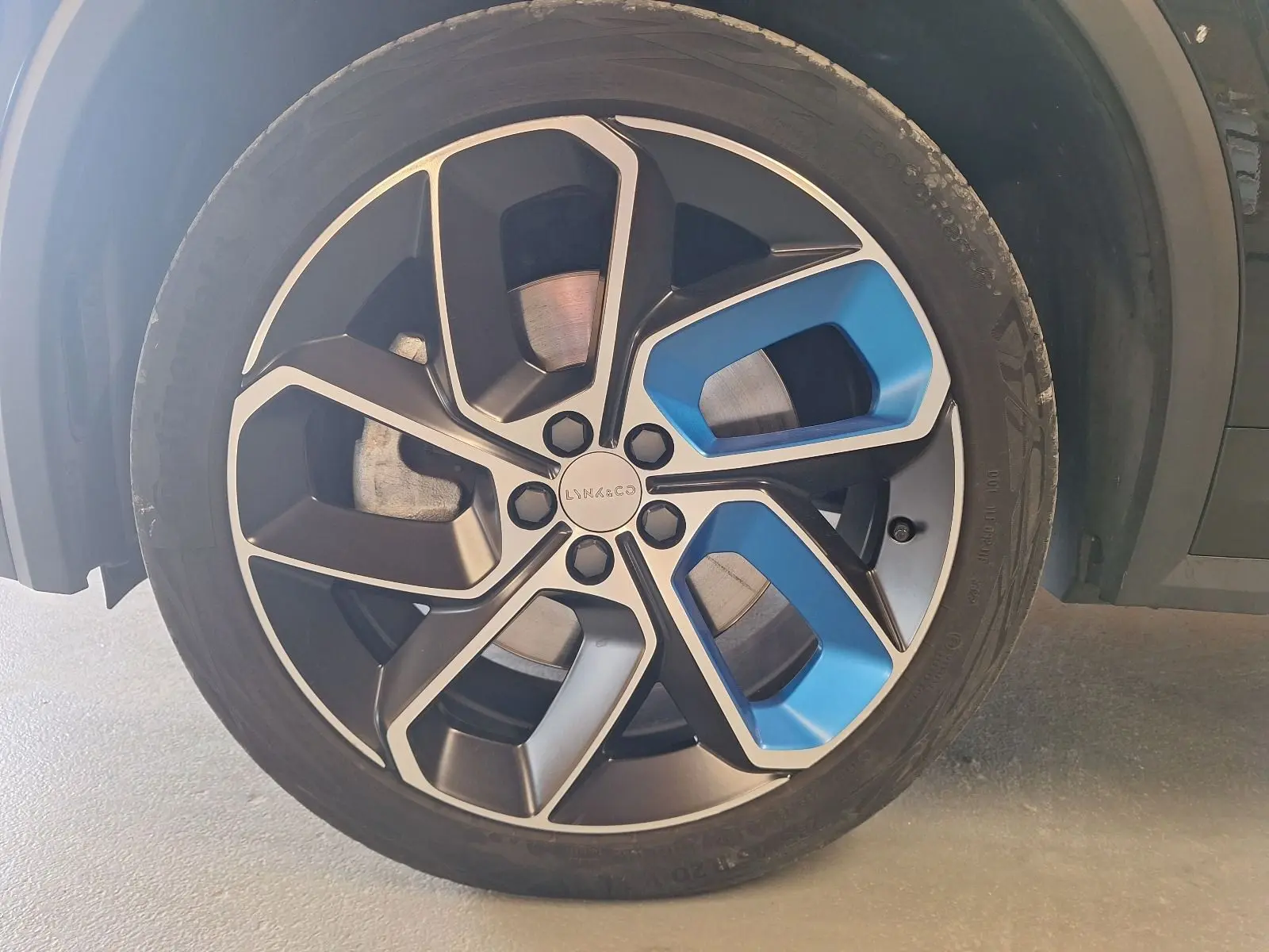 Gros plan sur la jante alliage 20 pouces noire et bleue du LYNK & CO 01 PHEV 2022, avec pneu Continental.