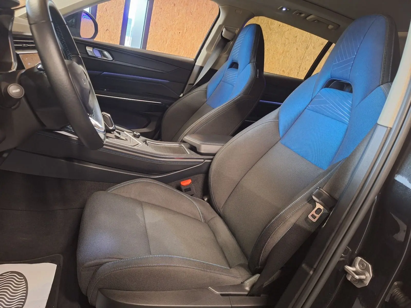 Vue intérieure côté conducteur du Lynk & Co 01 PHEV 2022 avec sièges avant bi-ton bleu et gris.