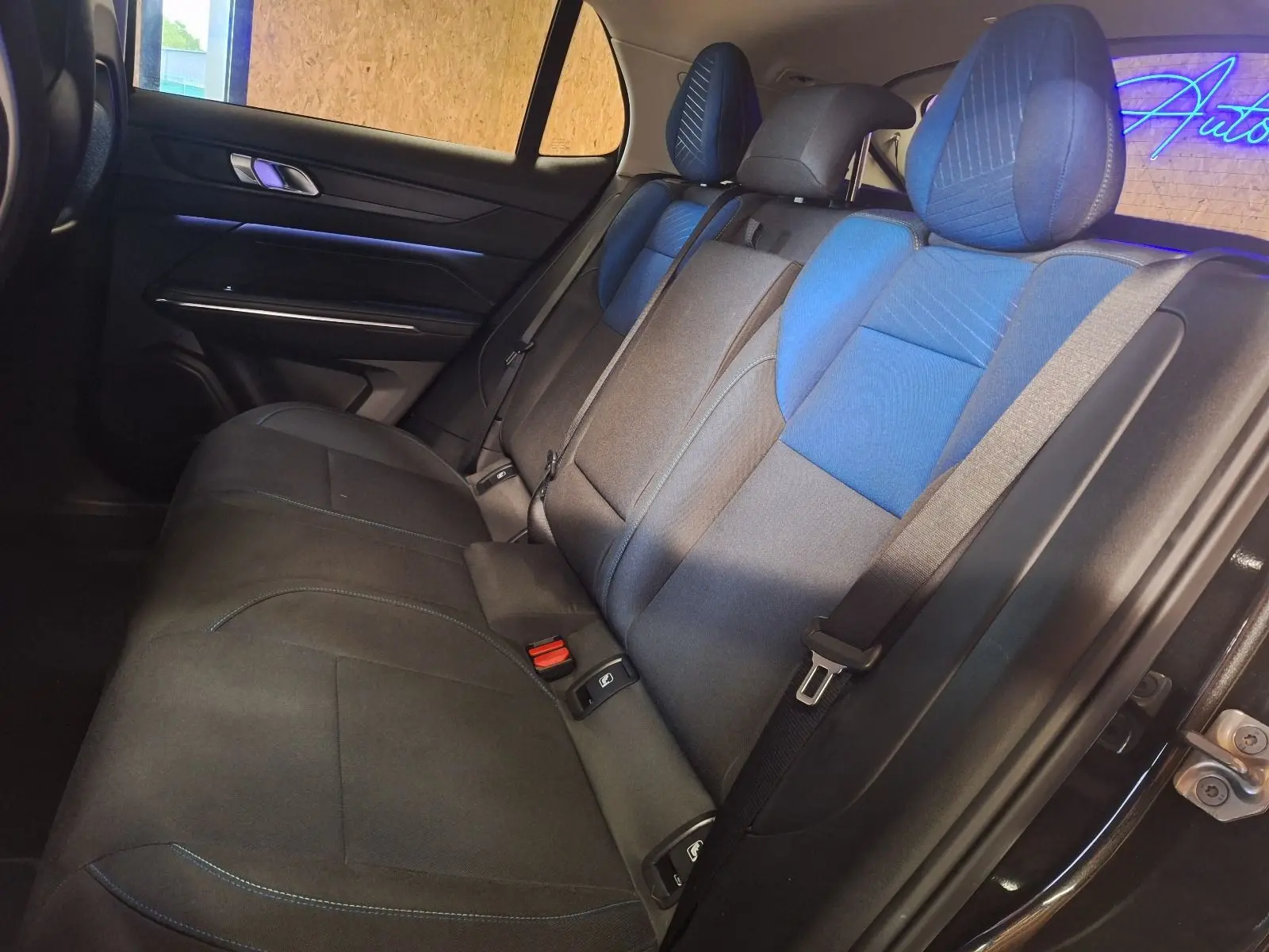 Vue latérale droite de la banquette arrière bicolore noire et bleue du Lynk & Co 01 PHEV 2022 avec ceintures de sécurité.