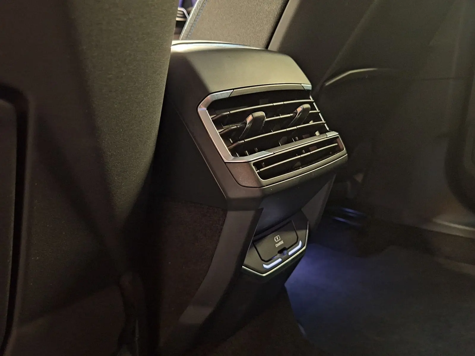 Gros plan sur la console arrière noire du Lynk & Co 01 PHEV 261 DCTH7 avec aérateurs et chargeur USB intégré.