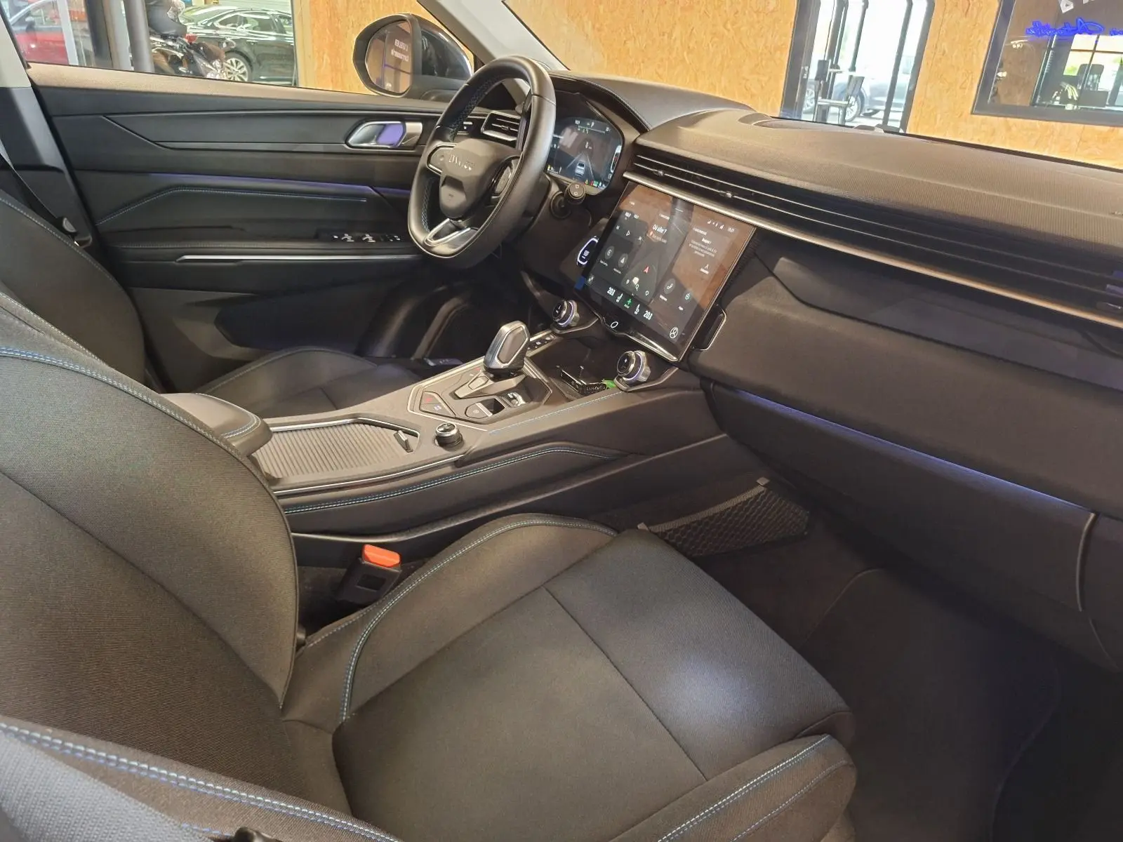 Vue intérieure côté conducteur du Lynk & Co 01 PHEV 2022 noir, avec tableau de bord et écran tactile central.