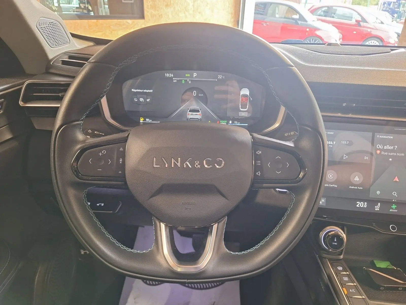 Vue rapprochée du volant noir de la Lynk & Co 01 PHEV 2022 avec tableau de bord numérique et écran tactile.