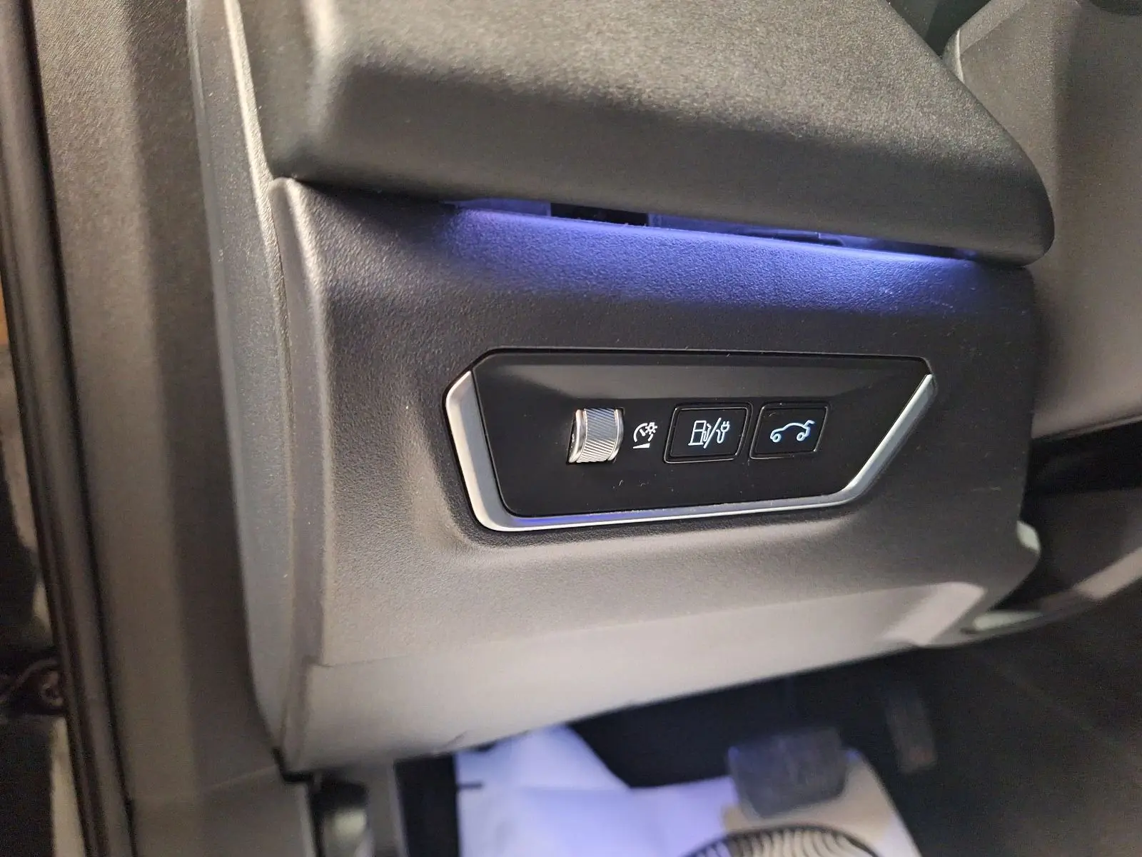 Détail des commandes d'ouverture du coffre et réglages, côté gauche intérieur d'un Lynk & Co 01 noir.