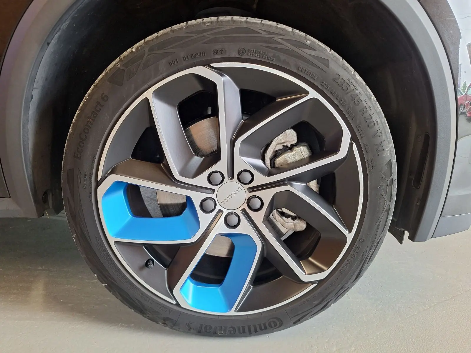Gros plan sur la jante avant droite noire et bleue du LYNK & CO 01 PHEV 2022 avec pneu Continental.