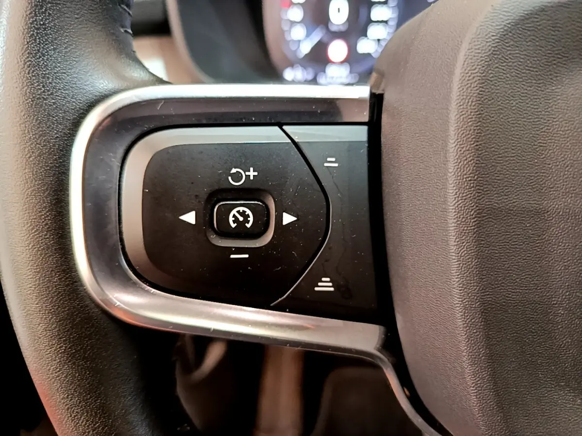 Gros plan sur les commandes de régulateur de vitesse au volant noir du Volvo XC40 T2 129 Momentum 2020.