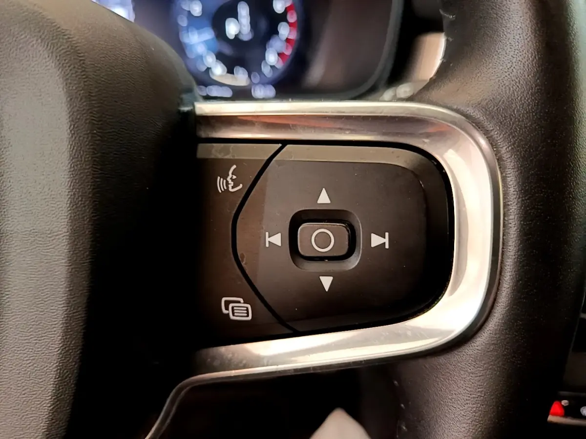 Gros plan sur les commandes multifonctions noires et argentées du volant du Volvo XC40 noir, version 2020.