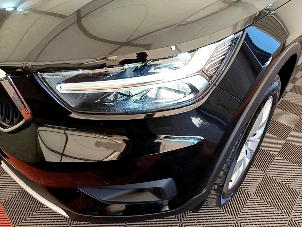 Gros plan sur l'avant droit noir brillant du Volvo XC40 T2 2020, mettant en valeur le phare LED et la roue.