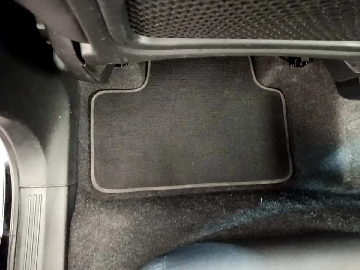 Vue rapprochée du tapis de sol noir côté passager avant du Volvo XC40 T2 2020, intérieur sombre.