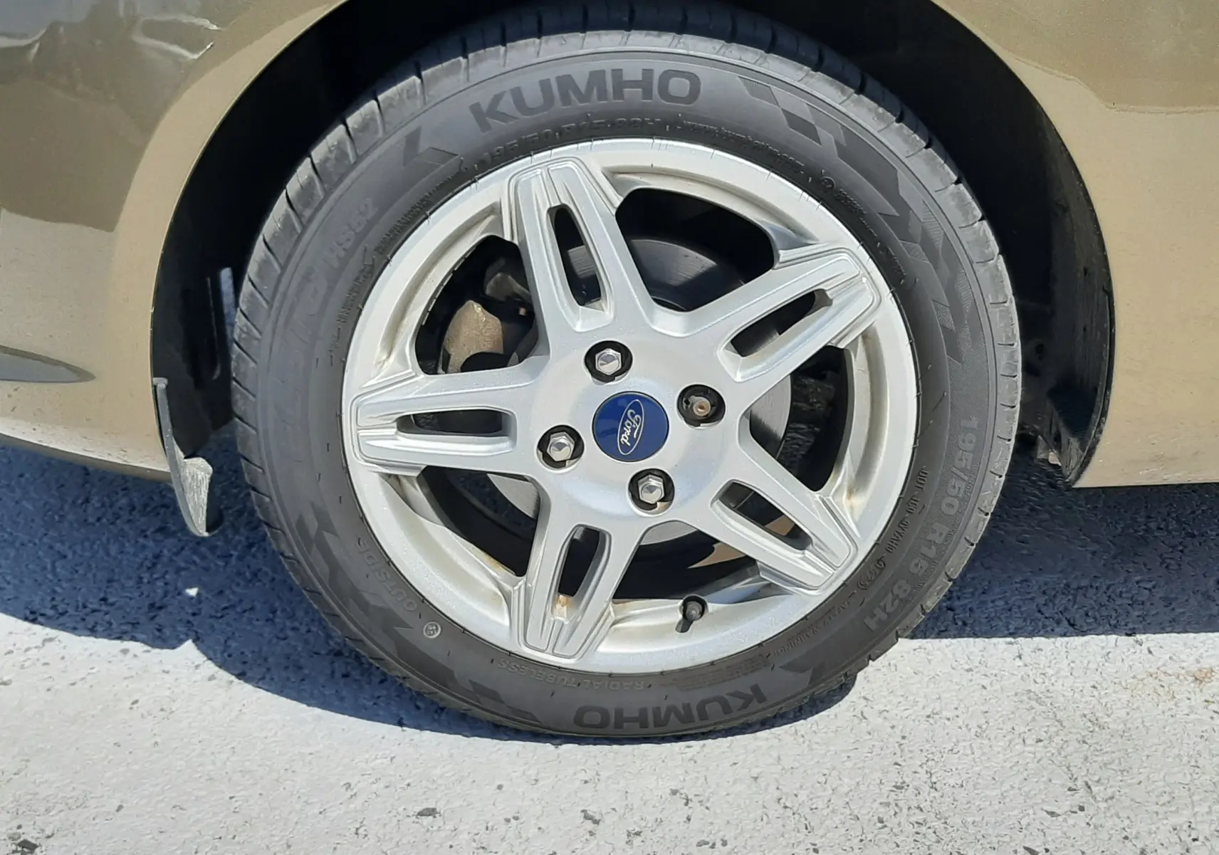 Gros plan sur la roue avant gauche d'une Ford Fiesta marron métal de 2013 avec jante alliage et pneu Kumho.