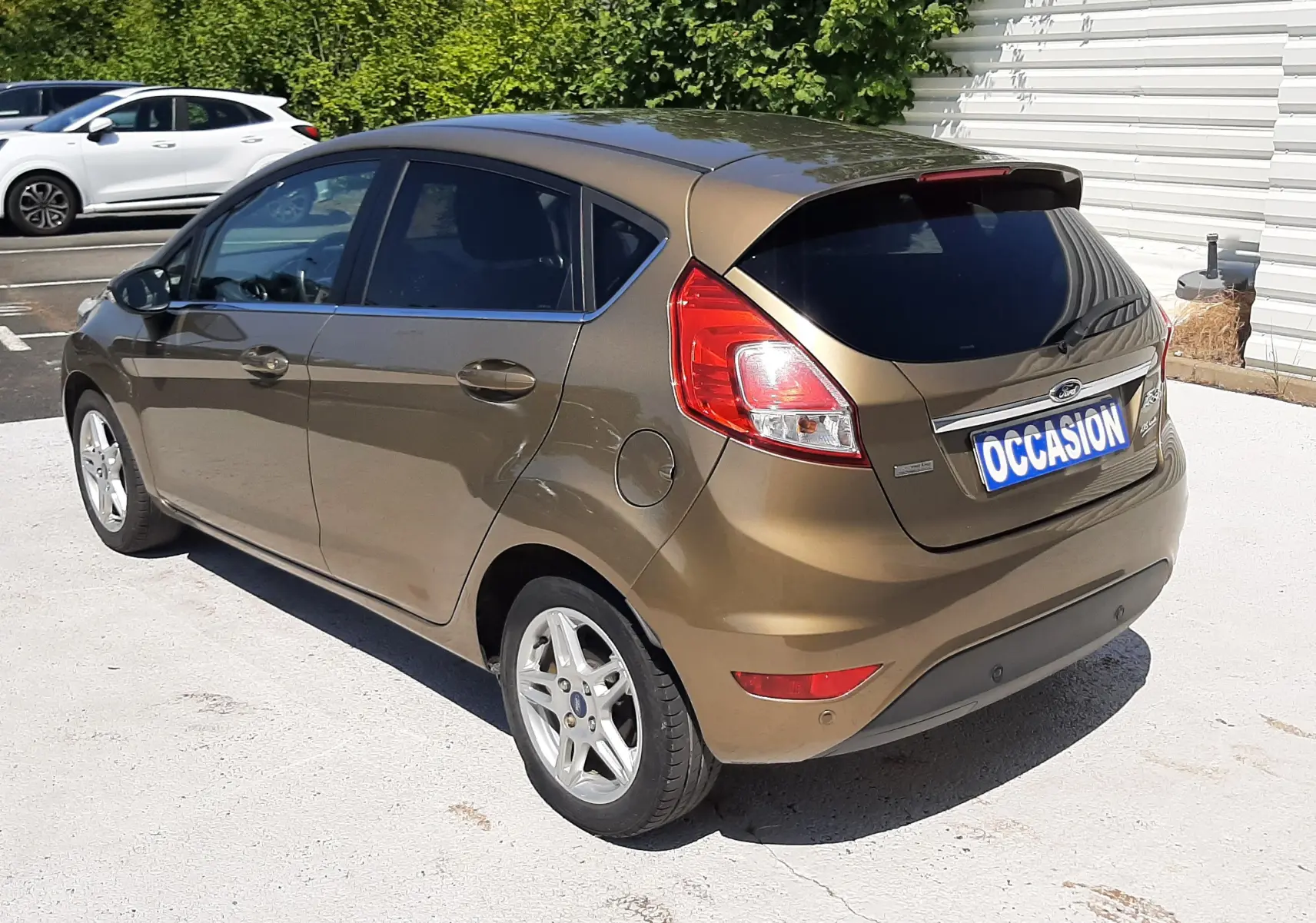Ford Fiesta 1.0 EcoBoost Titanium marron métal vue 3/4 arrière droit, avec jantes alliage et vitres teintées.