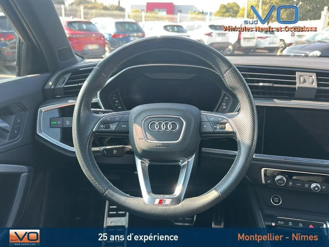Vue frontale du volant cuir perforé noir avec logo Audi et badge S line dans l'habitacle du Q3 Sportback 2020 noir.