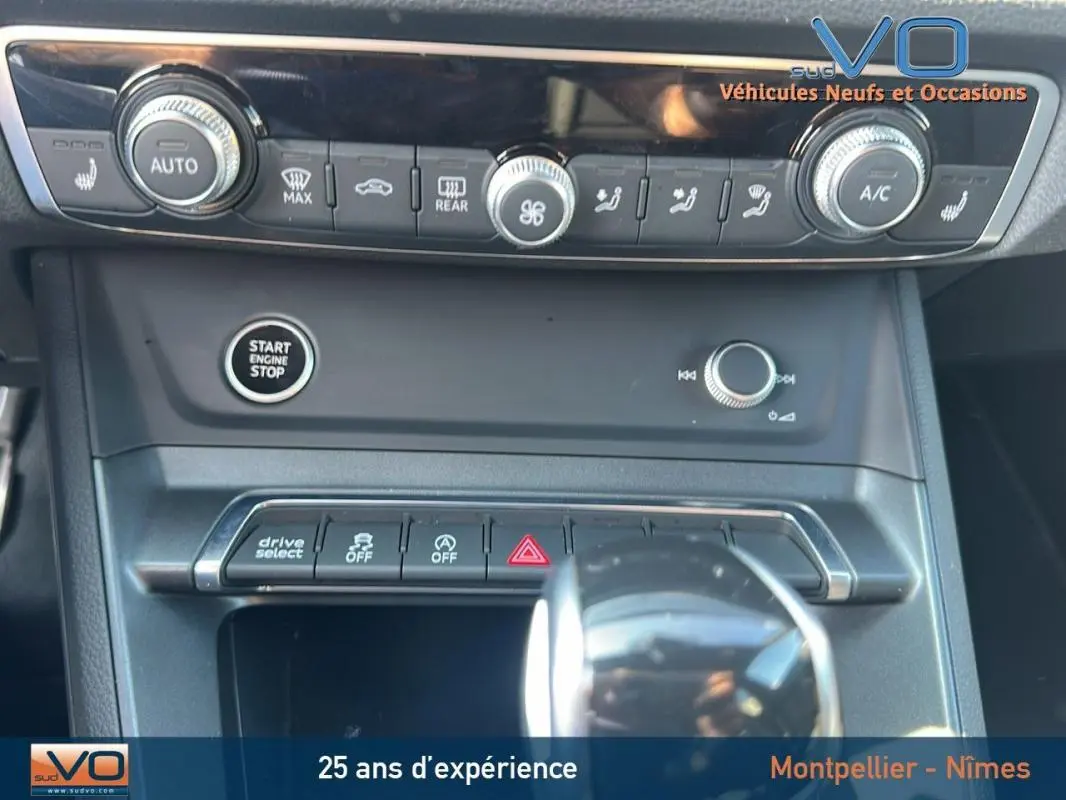 Vue rapprochée de la console centrale noire de l'Audi Q3 Sportback 35 TDI 2020 avec boutons de climatisation et démarrage moteur.