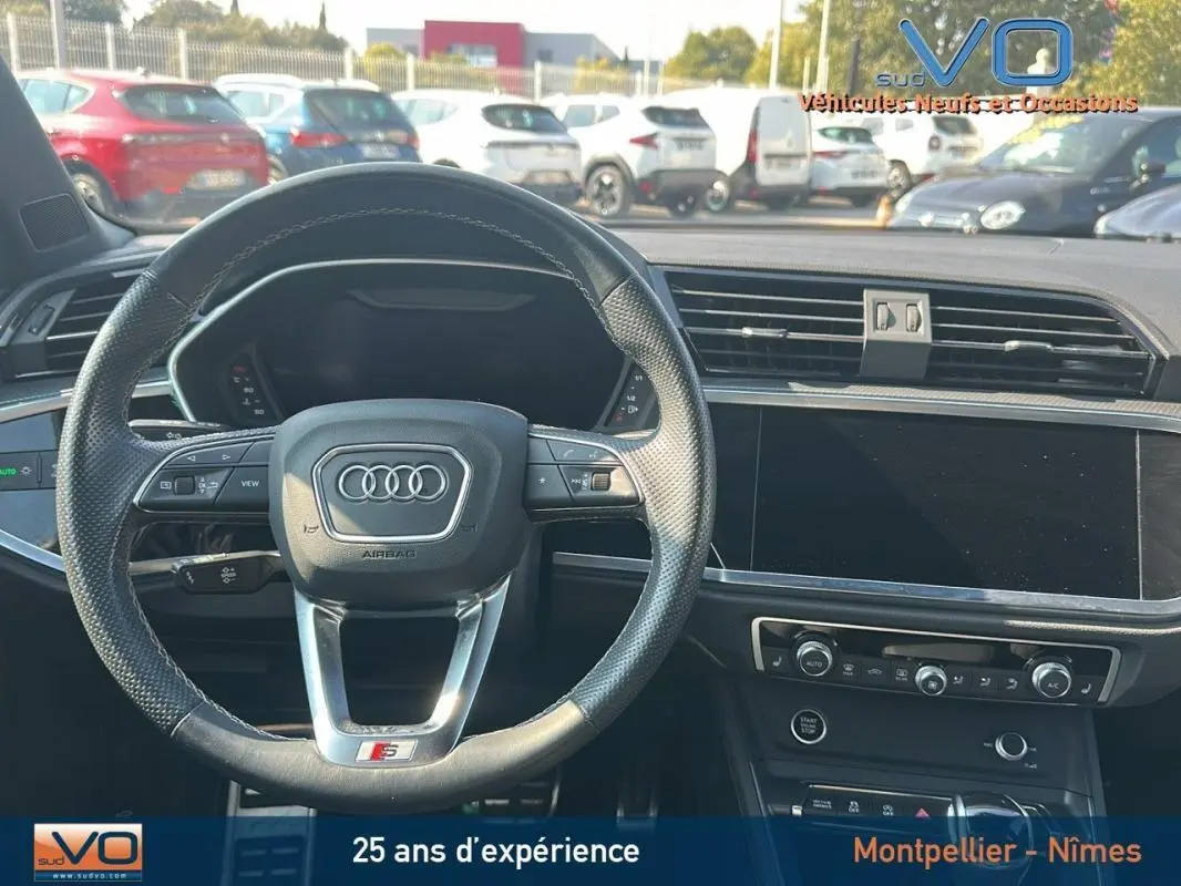 Vue intérieure centrée sur le volant noir perforé S line et le tableau de bord moderne de l'Audi Q3 Sportback 2020.