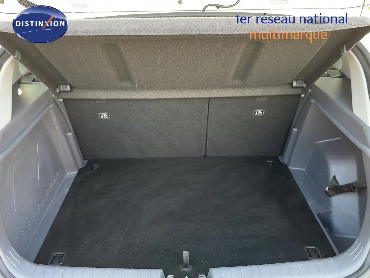 Coffre ouvert d’une Hyundai Bayon blanc polaire, vue arrière montrant l’espace de chargement vide et les finitions intérieures grises.