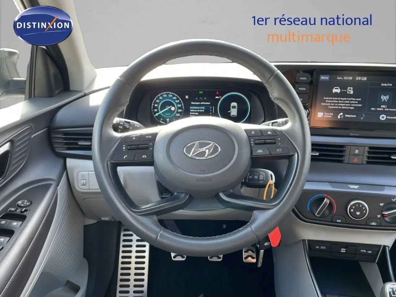 Vue intérieure centrée sur le volant cuir et le tableau de bord numérique du Hyundai Bayon blanc polaire 2022.