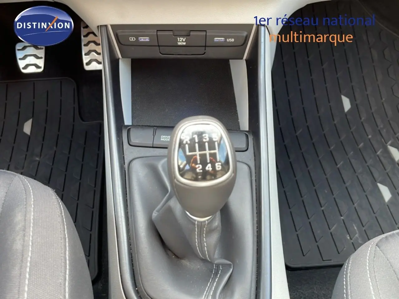 Le levier de vitesses manuel en gros plan au centre de la console d'une Hyundai Bayon blanche, intérieur tissu gris.