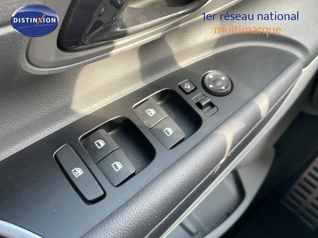 Gros plan sur les commandes des vitres et rétroviseurs côté conducteur de la Hyundai Bayon 2022 en intérieur noir.