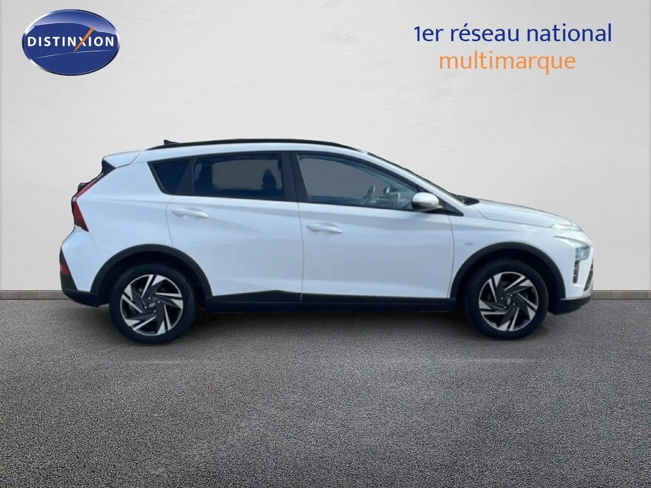 Profil droit du Hyundai Bayon blanc polaire 2022, version hybride avec jantes alliage et toit noir contrasté.