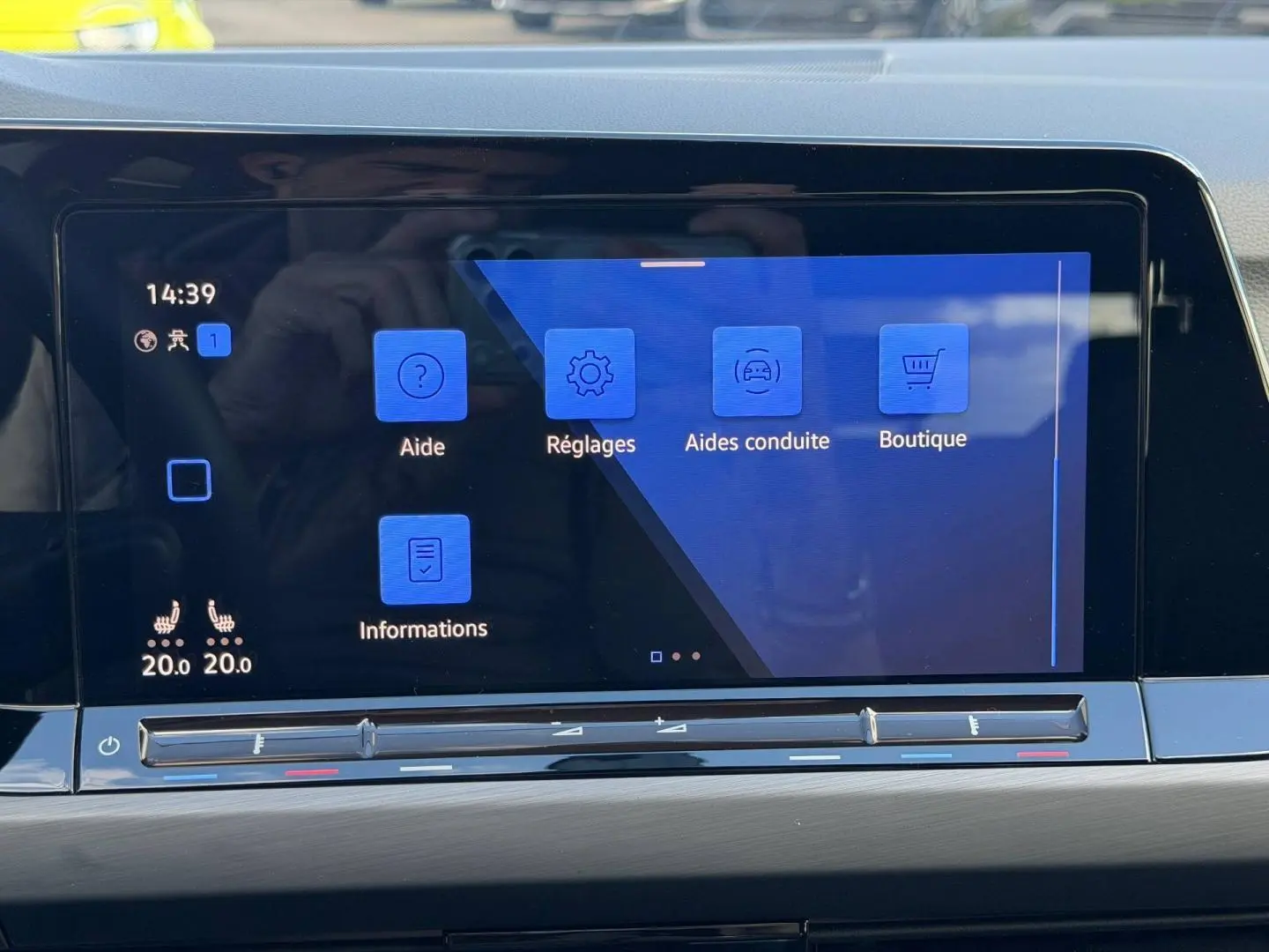 Écran tactile central de la Volkswagen Golf 2024 affichant les menus d’aide, réglages et conduite, intérieur gris.