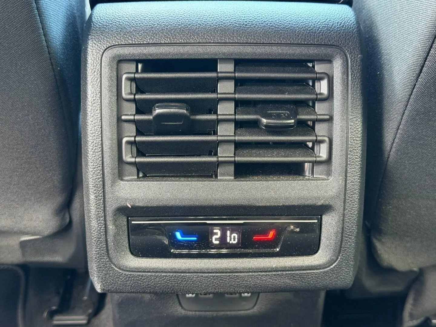 Gros plan sur la ventilation arrière et le réglage de la température à 21°C dans l’habitacle gris du Volkswagen Golf 2024.