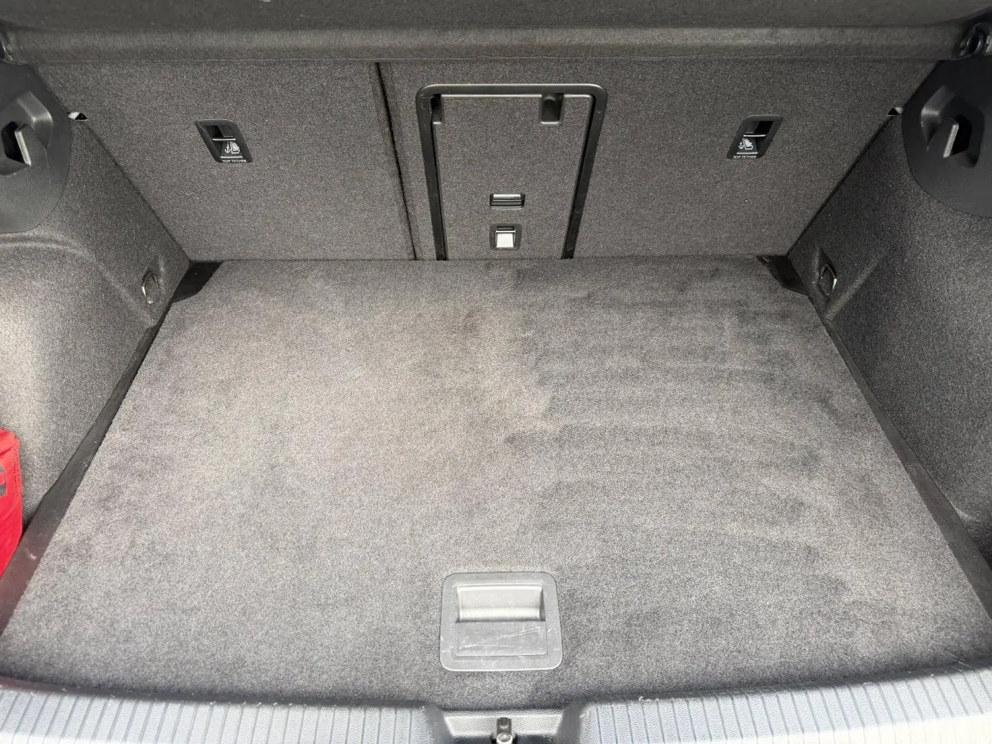 Coffre spacieux de Volkswagen Golf 1.5 TSI 2024, vue intérieure montrant le tapis gris et la trappe à skis centrale.