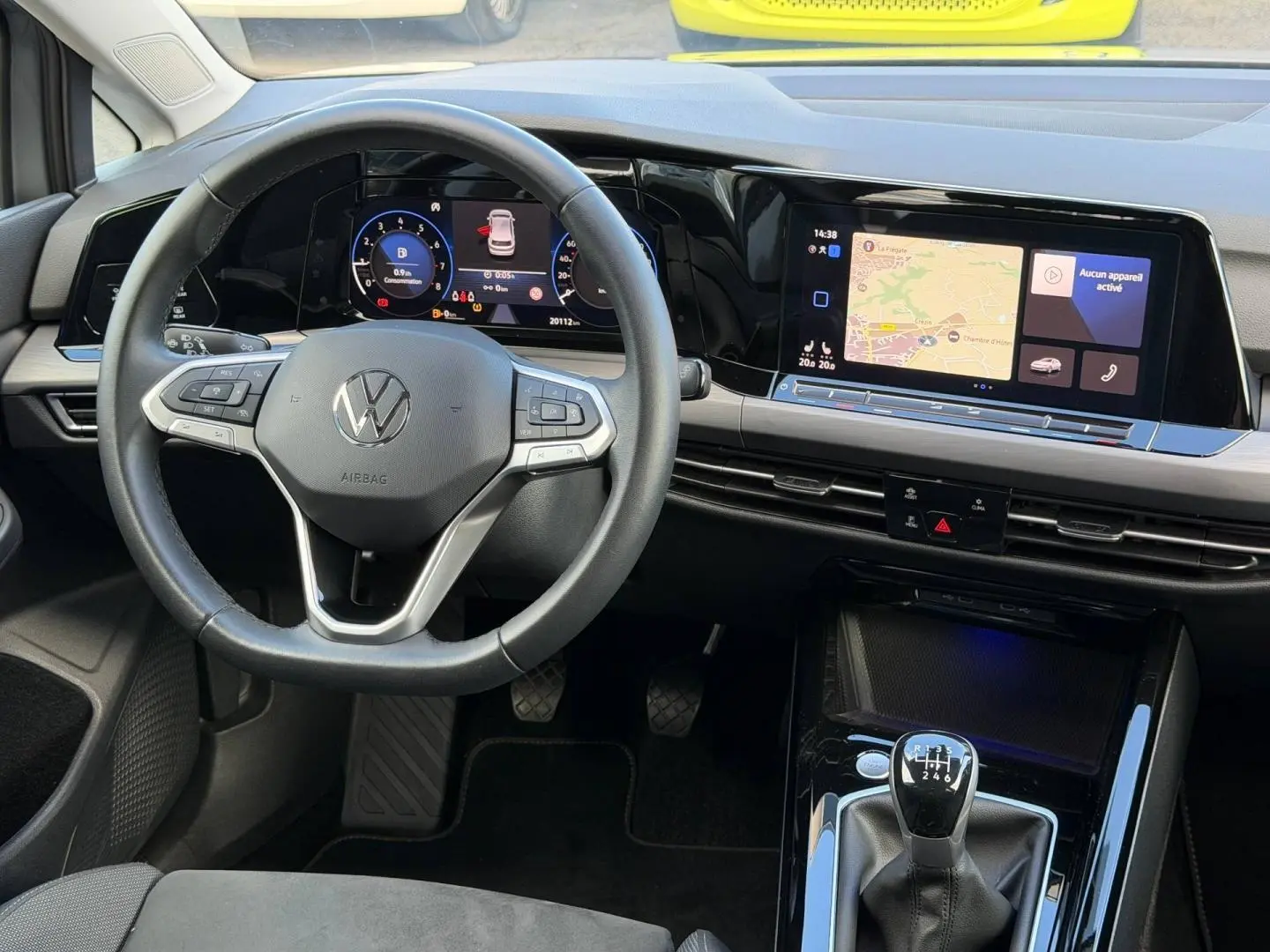 Vue intérieure avant de la Volkswagen Golf 2024, volant cuir multifonction et écran tactile avec navigation visible.
