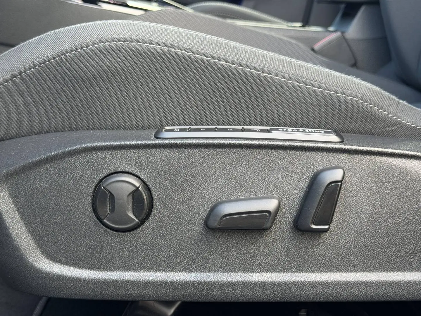 Détail des commandes de réglage électrique du siège avant gris d’une Volkswagen Golf 1.5 TSI Style 2024.