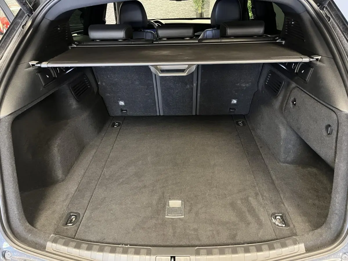 Vue arrière du coffre spacieux et noir de l'Alfa Romeo Stelvio 2.2 D Veloce 2024 avec cache-bagages rétractable.