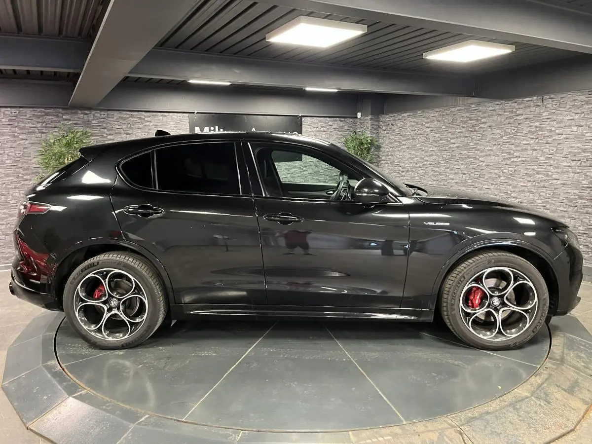 Profil droit de l'Alfa Romeo Stelvio Veloce 2024 noir Vulcano avec jantes 20 pouces et étriers Brembo rouges.