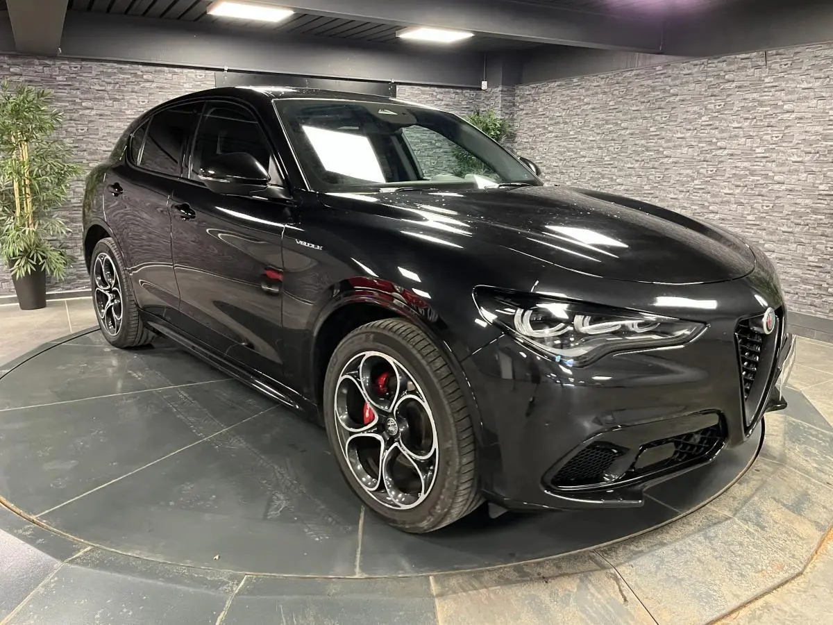 Alfa Romeo Stelvio Veloce noir Vulcano en 3/4 avant droit, avec jantes 20' Competizione et étriers Brembo rouges.