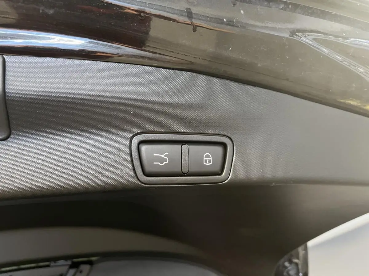 Gros plan sur les boutons d'ouverture et de verrouillage du hayon électrique noir d'un Alfa Romeo Stelvio 2024 noir Vulcano.