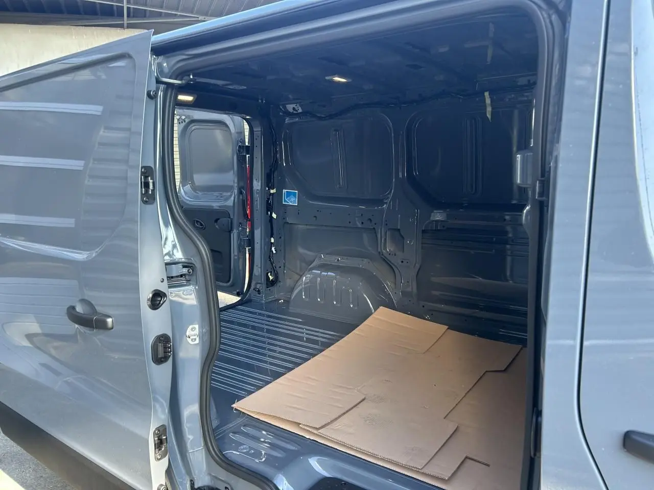 Vue rapprochée du volant gris du Renault Trafic Fourgon 2025, avec commandes intégrées et tableau de bord visible.