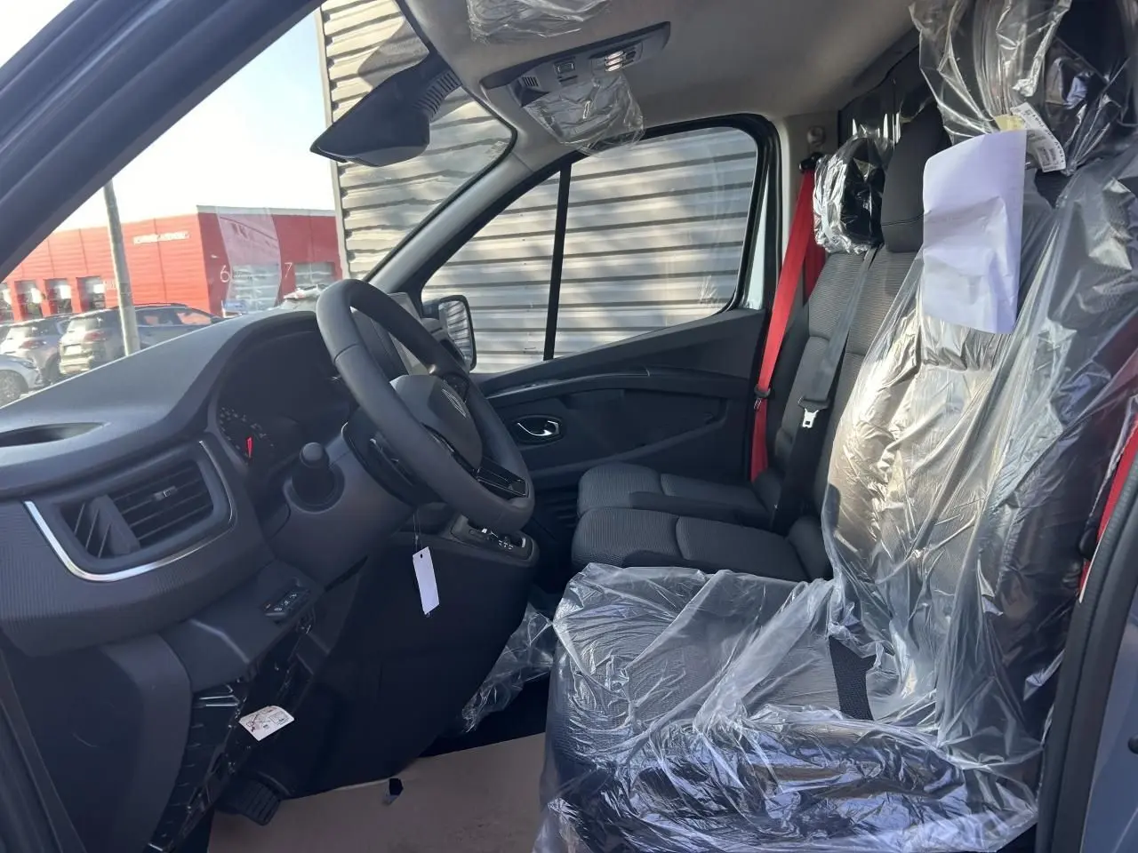 Vue arrière d’un Renault Trafic Fourgon gris urbain 2025, portes battantes fermées avec caméra et radar de recul visibles.