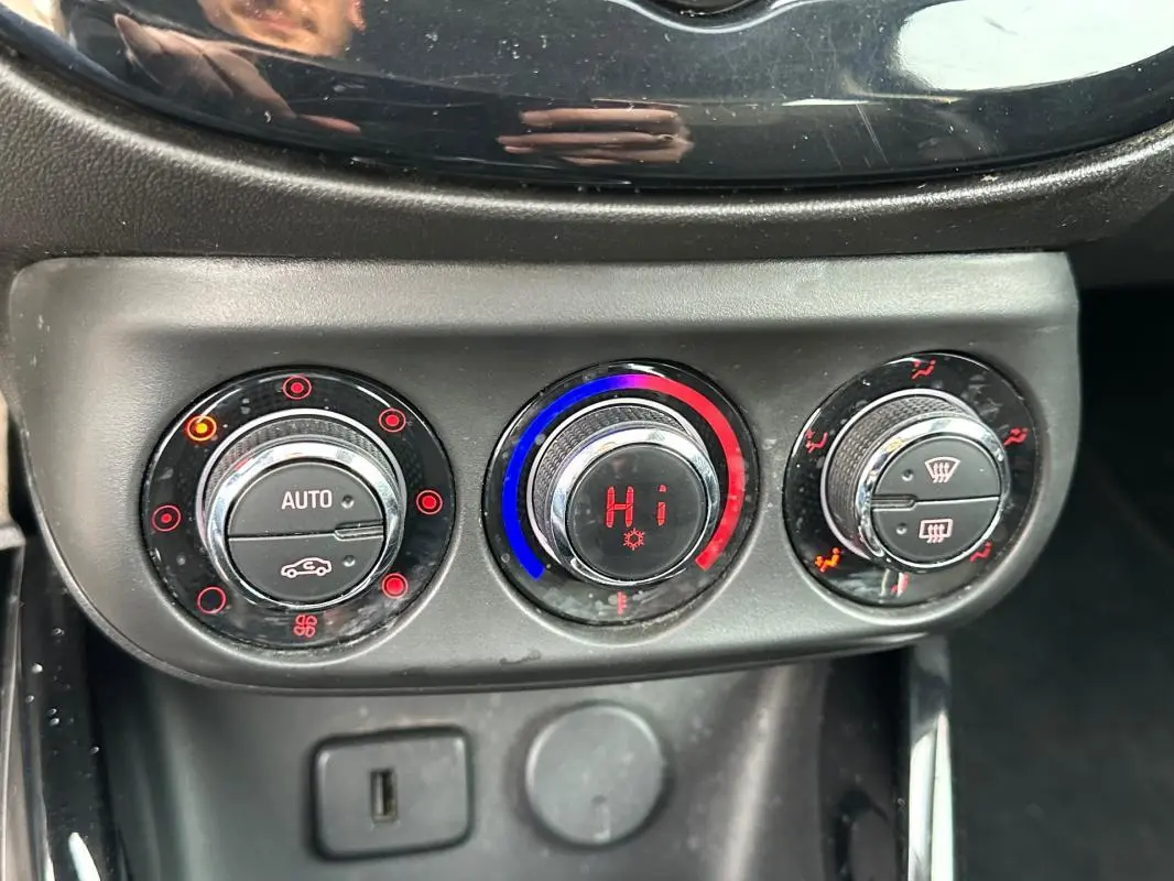 Gros plan sur les commandes de climatisation automatique de l'Opel Adam 2016, avec réglages en rouge et bleu.