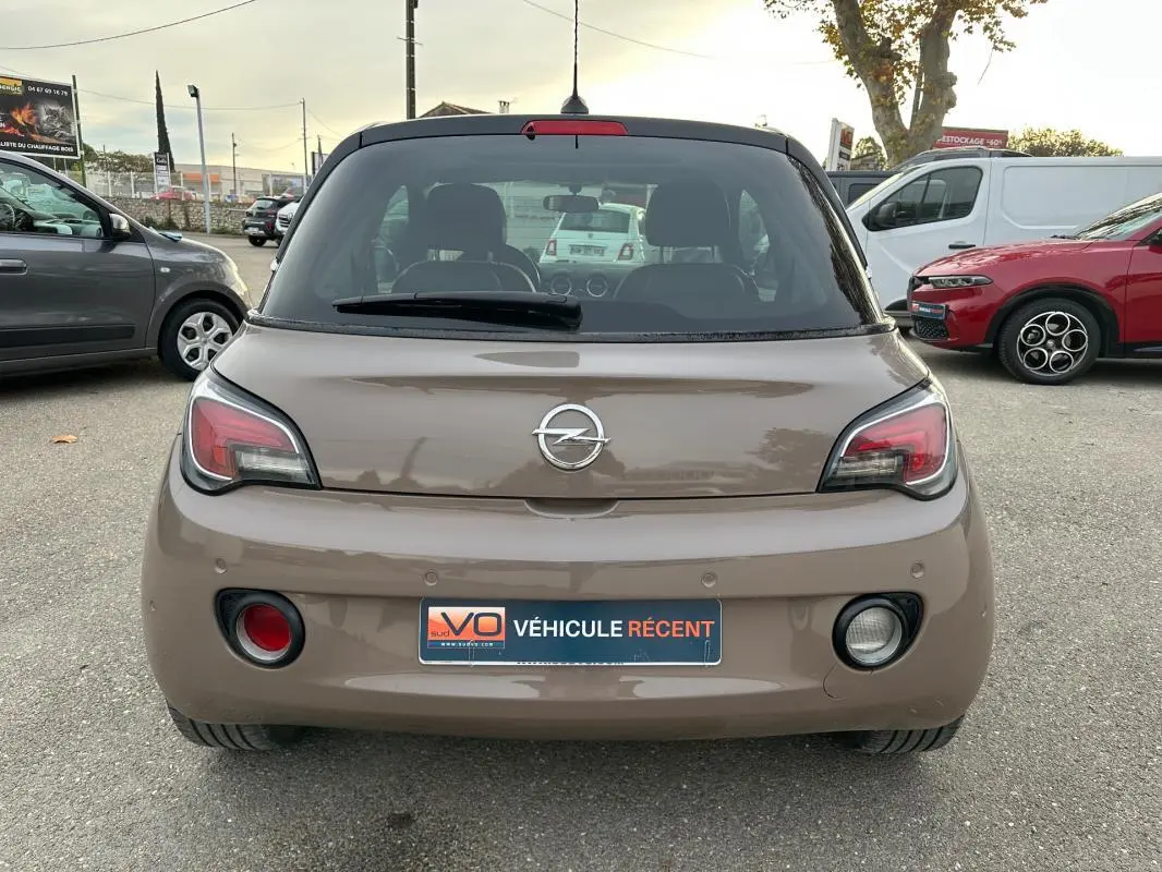 Vue arrière d'une Opel Adam marron 2016 avec feux distinctifs et plaque d'immatriculation "Véhicule récent" visible.